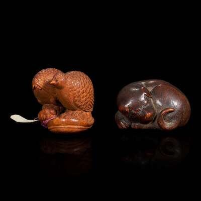 Two carved wood netsuke: a sleeping dog and a pair of quail