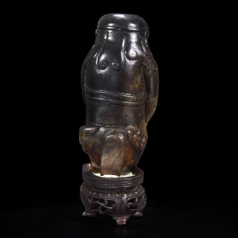An unusual Chinese dark brown-black jade carving of a Lohan